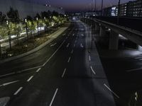 the highway is lined with traffic lights at night time and surrounded by an airport fence