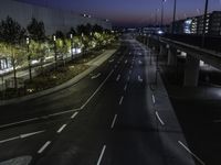 the highway is lined with traffic lights at night time and surrounded by an airport fence