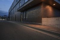 a photo of a large building lit by light fixtures and an oncoming fire hydrant