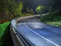 a road and a bridge at night with light on it with a long exposure effect