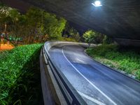 a road and a bridge at night with light on it with a long exposure effect