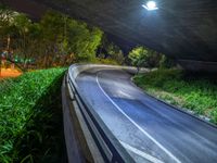 a road and a bridge at night with light on it with a long exposure effect