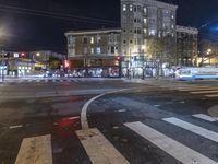 a traffic light at night on a city street with buildings and buses on the road