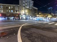 a traffic light at night on a city street with buildings and buses on the road