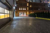 an alleyway with buildings at night, lit up by street lights, with a neon light in the distance