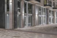 a view of the outside of an apartment building at night, showing off of the front entrance