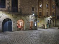 Night View of Barcelona City Street with Historic Architecture and Shopfronts