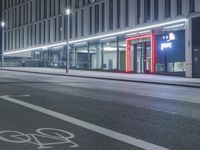 the empty city road is empty by the tall building in the background at night with light streaking on the buildings