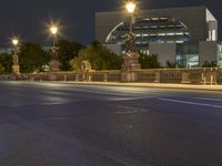 street at night with city lights, city streets and bridge on both sides of road