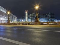 some street lights on a street and buildings at night time at city street with road and road