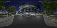 a photo taken at night from the street, of a large building with glass roof