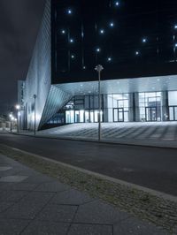 an empty street near a large modern structure at night's edge in a european country