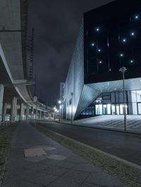 an empty street near a large modern structure at night's edge in a european country