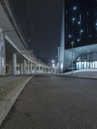 an empty street near a large modern structure at night's edge in a european country