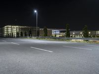 the night view shows several large buildings and streetlights near the roadway or other road