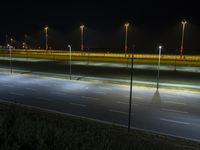 a view of a highway at night with a single vehicle parked along side it and on both sides of the freeway