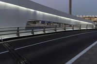 a view of a bridge that is lit up at night time and the street level is empty