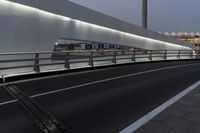 a view of a bridge that is lit up at night time and the street level is empty