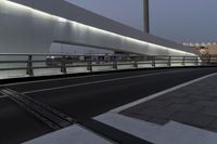 a view of a bridge that is lit up at night time and the street level is empty