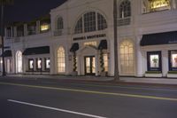 a building with lit lights on and street behind it that reads brooks brothers clothing company