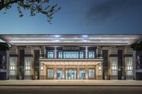 the front of a building in night lit up with lights on it's windows