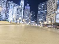 the lights are shining at night on the city street while cars pass by in a motion