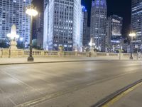 a black paved street in a big city at night and buildings on either side of it