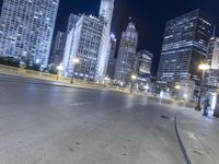 a black paved street in a big city at night and buildings on either side of it