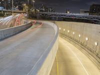 highway overpass with traffic at night, with buildings and street lights in background, with street lights on, street lamps to left