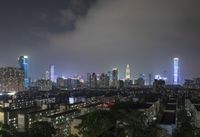 the view from the top of a high rise building, of the city lit up at night