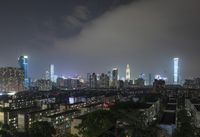 the view from the top of a high rise building, of the city lit up at night