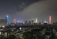 the view from the top of a high rise building, of the city lit up at night