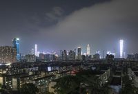 the view from the top of a high rise building, of the city lit up at night