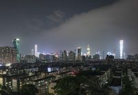 the view from the top of a high rise building, of the city lit up at night