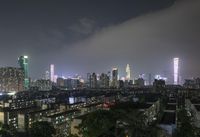 the view from the top of a high rise building, of the city lit up at night