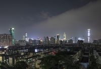 the view from the top of a high rise building, of the city lit up at night