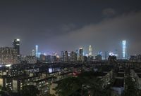 the view from the top of a high rise building, of the city lit up at night