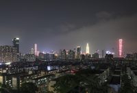 the view from the top of a high rise building, of the city lit up at night