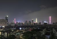 the view from the top of a high rise building, of the city lit up at night