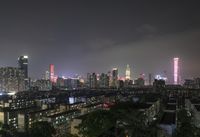 the view from the top of a high rise building, of the city lit up at night