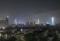 the view from the top of a high rise building, of the city lit up at night