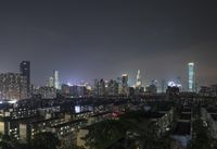 the view from the top of a high rise building, of the city lit up at night