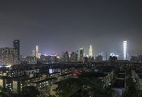 the view from the top of a high rise building, of the city lit up at night