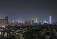 the view from the top of a high rise building, of the city lit up at night