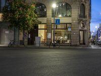a city street that has parked cars on it at night as cars wait for traffic