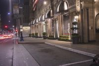 a city street at night with cars passing by at a corner in a cityscape