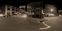 a night view of the street and building in a city area with no traffic at all