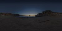 a picture taken with the 360 - angle lens at night of a scenic view of cliffs near a sea