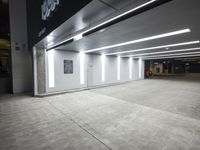 a empty parking lot with lights on from above and a wall on one of the floors