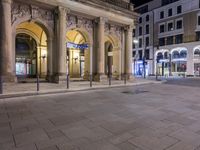 a empty plaza at night with the buildings in the background and many signs lit up